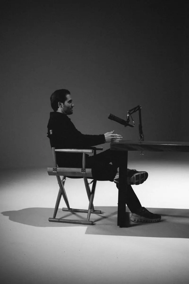 Robson à mesa em conversa, de perfil